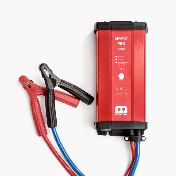 En röd batteriladdare med en blå och en röd sladd som går till två batteriklämmor.